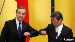 រដ្ឋមន្ត្រី​ការបរទេស​ចិន​លោក Wang Yi (ឆ្វេង) និង​សមភាគី​ជប៉ុន​របស់​លោក​​គឺ​លោក Toshimitsu Motegi ប៉ះកែងដៃ​គ្នា​នៅ​ពេល​ចាប់​ផ្ដើមកិច្ចពិភាក្សា​របស់​ពួកគេ ក្នុង​អំឡុងពេល​មាន​វិបត្តិ​កូវីដ១៩ ទីក្រុង​តូក្យូ ថ្ងៃទី២៤ ខែវិច្ឆិកា ឆ្នាំ២០២០។ 