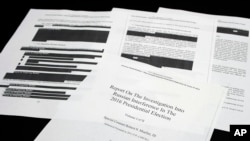 Four pages of the Mueller Report lay on a witness table in the House Intelligence Committee hearing room on Capitol Hill, in Washington, April 18, 2019.