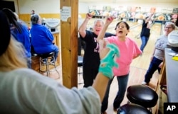 Jackie Suelflow, right, and Mikey Clanton, left, dance and sing during a ladies bowling night in Prairie du Chien, Wis., Wednesday, Jan. 18, 2017.