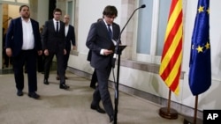 Catalonia regional President Carles Puigdemont arrives for a statement after signing the decree officially calling for the vote on a binding independence referendum, following a plenary session at the Parliament of Catalonia in Barcelona, Spain, Sept. 6, 