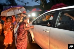 Hindu women favoring barring women of menstruating age from entering the Sabarimala temple scan vehicles at Nilackal, a base camp on way to the mountain shrine in Kerala, India, Oct. 16, 2018.