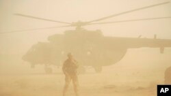 Tentara Rusia berjaga dekat sebuah helikopter militer yang akan lepas landas di sebuah pangkalan udara di Deir el-Zour, Suriah, 15 September, 2017.