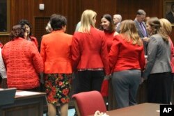 Female members of the Arizona House, from Republican and Democratic parties, hold hands to express support for Rep. Michelle Ugenti-Rita, center facing camera, as the House prepares to vote to possibly expel a member for sexual harassment in Phoenix, Arizona, Feb. 1, 2018.