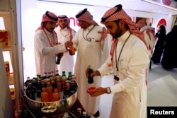 Saudi men buy soft drinks at Saudi Arabia's first commercial movie theater in Riyadh, Saudi Arabia, April 18, 2018.