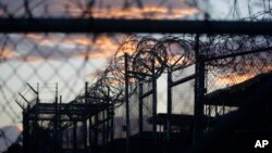 FILE - Dawn arrives at the now-closed Camp X-Ray, which was used as the first detention facility for al-Qaida and Taliban militants who were captured after the Sept. 11 attacks, at the Guantanamo Bay Naval Base, Cuba. The Obama administration is transferr