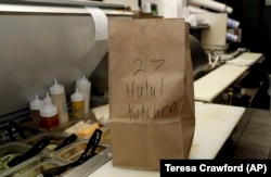 An order from the menu of Halal Kitchen is ready for pickup in a kitchen inside Frato's Pizza in Schaumburg, Ill., on Sept. 6, 2019.