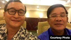 A widely shared photo on Cambodian social media, Cambodian opposition leader Sam Rainsy and Prime Minister Hun Sen take a selfie to affirm their 'culture of dialogue' at a dinner between the two families at Cambodiana Hotel in Phnom Penh, Sunday, July 12, 2015. (Courtesy of Sam Rainsy) 