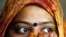 FILE - A woman wearing a bindi waits after casting her vote at a polling station in the old quarters of Delhi.