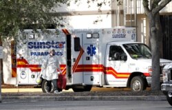 A paramedic dressed in personal protective equipment exits an ambulance at St. Petersburg General Hospital in Florida, July 18, 2020.