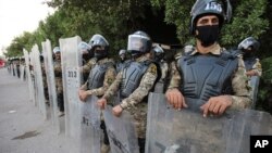 Riot police try to prevent protesters from storming the Iraqi Parliament Representation Building during anti-government demonstrations in Basra, Iraq, Tuesday, June 16, 2020. (AP Photo/Nabil al-Jurani)