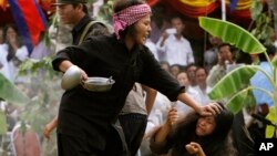 រូបភាព​ឯកសារ៖ និស្សិត​ពី​សាកល​វិទ្យាល័យ​ភូមិន្ទ​វិចិត្រ​សិល្បៈ សំដែង​ឡើង​វិញ​នូវ​សកម្មភាព​ដែល​ខ្មែរក្រហម​ធ្វើ​ទណ្ឌកម្ម​ទៅ​លើ​ប្រជា​ពលរដ្ឋ​ក្នុង​ពេល​ពួកគេ​កាន់អំណាច​ពី​ឆ្នាំ១៩៧៥ ដល់​១៩៧៩ នៅ​សារៈមន្ទីរ​ជើងឯក។