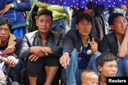 Men watch horse racing held during the Torch Festival celebrated by ethnic Yi minorities in Butuo County, Sichuan province, China, July 22, 2017.