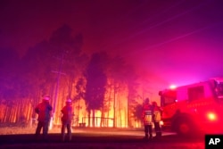 FILE - Firefighters battle a wildfire at Wooroloo, near Perth, Australia, Feb. 1, 2021.