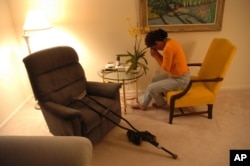 FILE - A patient recovering from hip replacement surgery holds a leaf from an orchid to her face as she practices meditation to deal with her pain.
