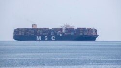 A cargo ship approaches the port of Piraeus near Athens, Greece, Tuesday, May 26, 2020. During the new coronavirus pandemic, about 150,000 seafarers are stranded at sea in need of crew changes, according to the International Chamber of Shipping. Roughly a