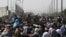 FILE - Afghans gather on a roadside near the military part of the airport in Kabul on August 20, 2021, hoping to flee from the country after the Taliban's military takeover of Afghanistan.