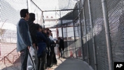 FILE - Illegal immigrants from Mexico wait in a holding area in El Paso, Texas, May 1, 2008. 