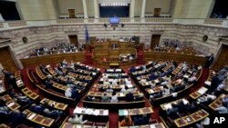 FILE - Greece's Prime Minister Alexis Tsipras delivers a speech during an emergency parliament session in Athens, July 23, 2015. 