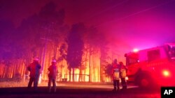 FILE - Firefighters battle a wildfire at Wooroloo, near Perth, Australia, Feb. 1, 2021. 