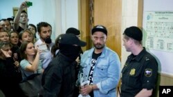 Russia's theater and film director Kirill Serebrennikov, second from right, is escorted in for hearings in a court in Moscow, Russia, Wednesday, Aug. 23, 2017. 