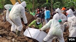 រូបឯកសារ៖ ក្រុមបញ្ចុះសព​មួយ បាន​បញ្ចុះ​ក្តារមឈូស​អ្នក​ដែល​បាន​ស្លាប់​ដោយសារ​ជំងឺ​កូវីដ១៩ នៅ​ទីបញ្ចុះសព​ពិសេស​មួយ​នៅ​ភាគខាងជើង​ទីក្រុង​ហ្សាការតា ប្រទេស​ឥណ្ឌូណេស៊ី​នៅ​ថ្ងៃទី៨ ខែកក្កដា ឆ្នាំ២០២១។