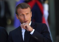 French President Emmanuel Macron pauses after greeting Britain's Prime Minister Boris Johnson at the Elysee Palace, Aug. 22, 2019 in Paris.