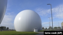 Satellite dishes inside Kevlar domes at the Kester Satellite Ground Station in Kester, Belgium, Thursday, Oct. 15, 2020. (AP Photo/Lorne Cook)