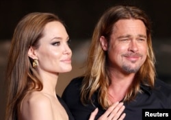 FILE - Hollywood actor Brad Pitt and actress Angelina Jolie make an appearance before fans at the Japan premiere of Pitt's movie 'World War Z' in Tokyo, July 2013.