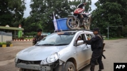 This photo taken on July 2, 2024 shows members of the ethnic armed group Ta'ang National Liberation Army (TNLA) inspecting a car at a checkpoint in the town of Kyaukme in Myanmar's northern Shan State.