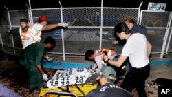 Para petugas penyelamat Pakistan mengangkut korban-korban tewas dari lokasi ledakan di sebuah taman di Lahore, Minggu (27/3).