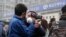 FILE - A plainclothes policeman grabs the hand of a foreign journalist as he prevents him from filming the supporters of rights lawyer Pu Zhiqiang's gathering near the Beijing Second Intermediate People's Court in Beijing, Dec. 14, 2015. 