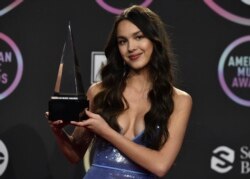 Penyanyi Olivia Rodrigo berpose dengan penghargaan yang diraihnya dalam ajang America Music Awards 2021 di Microsoft Theater di Los Angeles, pada 21 November 2021. (Foto: Invision/AP/Jordan Strauss)