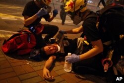 Medical workers help a protester in pain from tear gas fired by policemen on a street in Hong Kong, Sunday, July 21, 2019. Hong Kong police have thrown tear gas canisters at protesters after they refused to disperse. Hundreds of thousands of people…