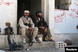 Rebel fighters rest with their weapons in Quneitra countryside, Syria Sept. 10, 2016.