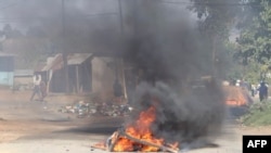 FILE - A barricade is set ablaze in the road during a protest in Mbabane, Eswatini, June 29, 2021. 