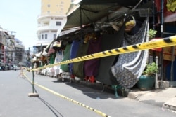 រូប​ឯកសារ៖ បុរសម្នាក់កំពុងដើរកាត់ខាងមុខផ្សារចាស់ ដែលកំពុងត្រូវបិទដំណើរការលក់ដូរ ក្រោយរដ្ឋាភិបាលប្រកាសបិទផ្សារមិនរៀបរយទូទាំងរាជធានី ដើម្បីទប់ស្កាត់ការរីករាលដាលជំងឺកូវីដ១៩ ក្នុងអំឡុងពេលបិទខ្ទប់នៅរាជធានីភ្នំពេញ និងក្រុងតាខ្មៅ ថ្ងៃទី២៦ ខែមេសា ឆ្នាំ២០២១។ (កាន់ វិច្ឆិកា/វីអូអេ)