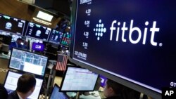 The logo for FItbit appears above a trading post on the floor of the New York Stock Exchange, Oct. 28, 2019. 