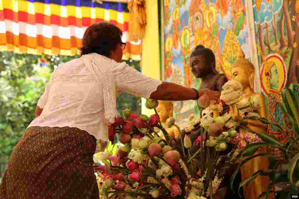 ពុទ្ធសាសនិក​មួយ​រូប យក​ភួង​ផ្កាម្លិះ​ថ្វាយ​ព្រះ​នៅ​ ថ្ងៃបុណ្យ​ភ្ជុំបិណ្ឌ​ក្នុង​វត្ត​មួយ​កណ្តាល​រាជធានី​ភ្នំពេញ កាលពី​ថ្ងៃទី១ ខែតុលា ឆ្នាំ២០១៦។ (ហ៊ាន សុជាតា/VOA)