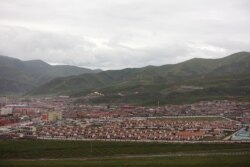 FILE - Houses for nomad families relocated from Madoi county are seen at the resettlement village of Heyuan inside a walled compound in Maqen county, Golog Tibetan Autonomous Prefecture, Qinghai province, China, Aug. 30, 2019.