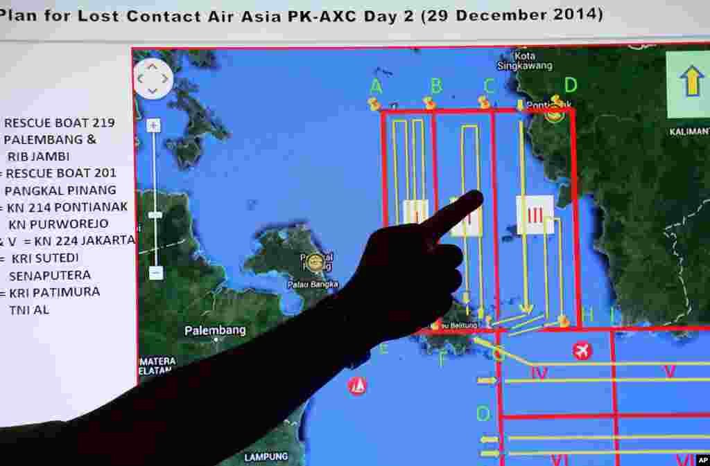 Seorang anggota BASARNAS menunjuk pada peta wilayah pencarian dalam briefing sebelum operasi pencarian pesawat AirAsia QZ8501, di pos Pangkal Pinang di pulau Sumatra, Indonesia, 29 Desember 2014.