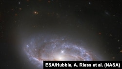 资料照片：美国宇航局/欧空局哈勃太空望远镜深入宇宙瞥见的无数的臂状结构，这些结构横跨这个被称为NGC 2608的螺旋星系。(美国宇航局提供)