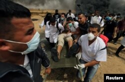 A wounded Palestinian is evacuated during clashes with Israeli troops at a protest where Palestinians demand the right to return to their homeland, at the Israel-Gaza border in the southern Gaza Strip, April 20, 2018.