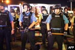 FILE - Police are deployed during a civil disobedience action in Ferguson, Missouri, Aug. 10, 2015. A recent report shows that, in hundreds of U.S. police departments, the percentage of white police officers is more than 30 percent higher than populations in the communities they serve.