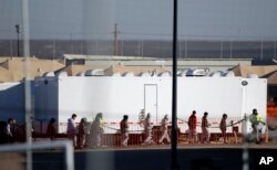 Migrant teens walk in a line through the Tornillo detention camp in Tornillo, Texas, Thursday, Dec. 13, 2018. The Trump administration announced in June 2018 that it would open the temporary shelter for up to 360 migrant children in this isolated corner of the Texas desert. Six months later, the facility has expanded into a detention camp holding thousands of teenagers.