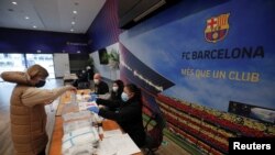 A woman casts her ballot in a polling station at FC Barcelona's Auditorium, next to Camp Nou stadium, during regional elections in Catalonia, amid the outbreak of the coronavirus disease (COVID-19), in Barcelona, Spain, Feb. 14, 2021. 