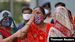A woman grieves after her husband died from the coronavirus, outside a mortuary of a COVID-19 hospital in Ahmedabad, India, May 8, 2021.