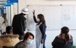 FILE - A health worker talks to a vaccine trials' volunteer in Johannesburg, South Africa, August 27, 2020. (REUTERS/Siphiwe Sibeko)