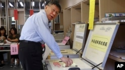 FILE - Taipei Mayor Ko Wen-je casts his ballot at a polling station, Nov. 24, 2018, in Taipei, Taiwan.