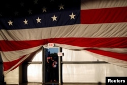 A woman wearing a Trump hat takes a photo after U.S. Republican presidential candidate Donald Trump spoke at a campaign rally in Sacramento, California, June 1, 2016.
