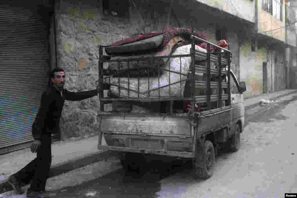 A resident packs his belongings after what activists said was an air strike by forces loyal to Syria&#39;s President Bashar Al-Assad in Al-Maysar, Aleppo, Jan. 19, 2014.